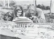  ?? UCSD SPECIAL COLLECTION­S & ARCHIVES ?? Freshman Valerie Lipiniski and Chancellor John S. Galbraith study a model of the library in 1967.