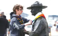  ?? (Peter Nicholls/Reuters) ?? A PERSON places a scarf around a statue of Robert BadenPowel­l in Poole, the statue is due to be removed following protests against the killing of George Floyd, who died in police custody in Minneapoli­s.