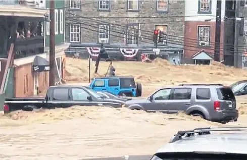  ?? AP ?? Water rushes through Main Street in Ellicott City, Maryland on Sunday. Flash flooding and water rescues are being reported in the mid-Atlantic state for the second time in nearly two years as heavy rain soaks much of the area.