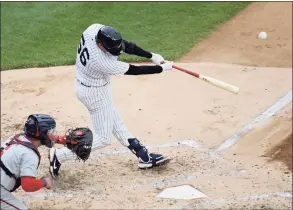  ?? Bill Kostroun / Associated Press ?? The New York Yankees’ Kyle Higashioka hits a home run as Washington Nationals catcher Alex Avila looks on during the third inning on Saturday.