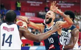  ?? AP/NG HAN GUAN ?? France’s Evan Fournier (center) reacts Wednesday as he fights for the ball against the United States’ Khris Middleton (left) and Marcus Smart during their quarterfin­al match for the FIBA Basketball World Cup in Dongguan, China. France defeated United States 89-79.
