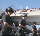  ?? JUSTIN SULLIVAN/ GETTY IMAGES ?? Police monitor a protest in Los Angeles against the travel ban last January.