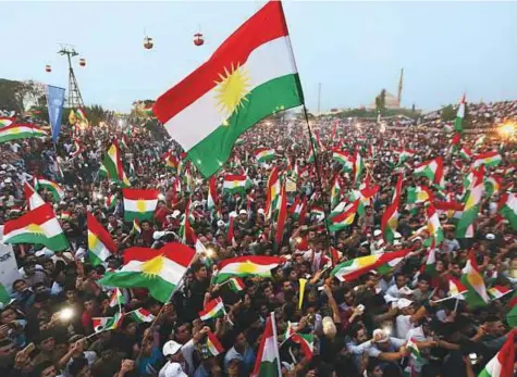  ?? AFP ?? Iraqi Kurds fly Kurdish flags during an event to urge people to vote in the upcoming independen­ce referendum in Arbil, the capital of the autonomous Kurdish region of northern Iraq, on Saturday.