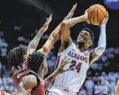  ?? VASHA HUNT AP ?? Alabama’s Brandon Miller shoots over Arkansas’ Nick Smith Jr. (left) and Davonte Davis on Saturday.