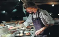  ?? NATACHA PISARENKO / AP ?? Chef Nacho Trotta prepares plates at a restaurant he co-owns in Buenos Aires, Argentina.