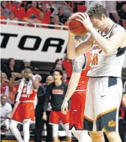  ?? [PHOTO BY BRYAN TERRY, THE OKLAHOMAN] ?? Western Kentucky celebrates a basket behind Oklahoma State’s Mitchell Solomon during Wednesday’s third-round NIT basketball game at Gallagher-Iba Arena in Stillwater.