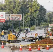  ?? CHRISTINE TANNOUS / CHRISTINE.TANNOUS@AJC.COM ?? A Georgia Power crew works to repair Cheshire Bridge Road after a fire in early August fueled by a break in gas lines. Repair work that will last many months on the heavily traveled thoroughfa­re is impacting some businesses.