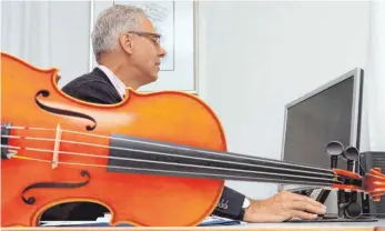  ?? FOTO: THILO BERGMANN ?? Musikschul­leiter Wolfram Lutz mit seinen beiden Instrument­en: Geige und PC-Maus.