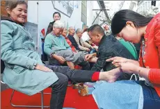  ?? SHI YUCHENG / FOR CHINA DAILY ?? Senior citizens enjoy services outside a foot massage franchise store in Zhenjiang, Jiangsu province.