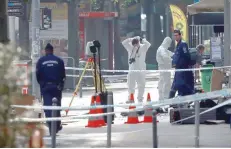  ?? — AFP ?? Hungarian police officials investigat­e in Budapest after an explosion of unknown origin injured two passing police officers on Sunday.