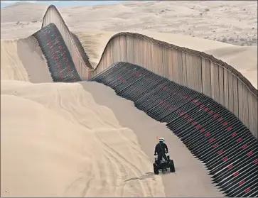  ?? Don Bartletti Los Angeles Times ?? A BORDER agent inspects a “floating fence” at California’s Imperial Sand Dunes. The fence can be raised to match the sand. Agents in Operation Blazing Sands say they want to stop border crossers and to save lives.