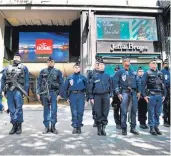  ??  ?? Clockwise from main: People look at a bullet hole in a window near to the Marks and Spencer store on the Champs Elysees in Paris following Thursday’s shooting of a police officer; a woman kisses a flower in tribute; armed police stand to attention near...