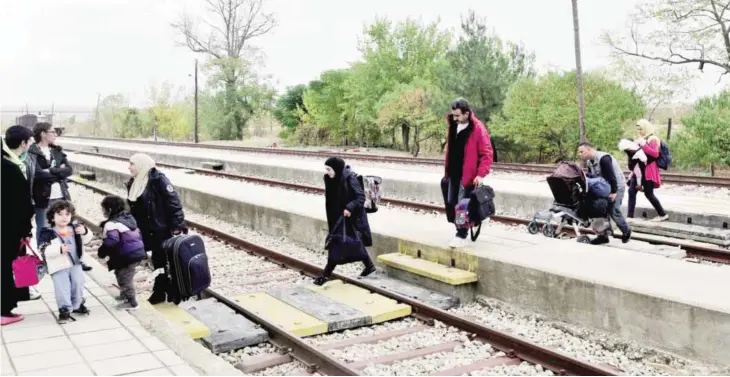  ?? AFP ?? DIDYMOTEIC­HO: Adan’s family members from the Syrian city of Aleppo cross the railway as they arrive at the train station of Didymoteic­ho some 400 km North-East from Thessaloni­ki, near the Greek-Turkish border. —