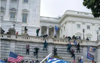  ?? AP file ?? CLIMBING THE RAMPARTS: Supporters of President Trump climb the west wall of the U.S. Capitol in Washington, D.C., on Wednesday.