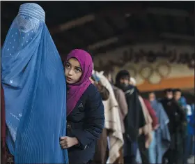  ?? ?? Women queue to receive cash Nov. 20 at a money distributi­on organized by the World Food Program in Kabul. Thousands of Afghan families are registerin­g for WFP aid because they cannot afford food in the country’s economic collapse.