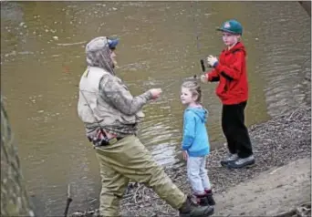  ?? ANNE NEBORAK – DIGITAL FIRST MEDIA ?? Patrick McGinnis of Drexel Hill is teaching to fish at Darby Creek in Clifton Heights. his daughter, Melanie, 5, and son, Thomas, how
