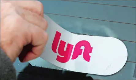 ?? GENE J. PUSKAR/AP PHOTO ?? In this 2018 file photo, a Lyft logo is installed on a Lyft driver’s car in Pittsburgh. Lyft says it’s readying for an initial public offering of its shares. The ride sharing service announced last week that it confidenti­ally submitted a draft registrati­on statement for the proposed IPO.