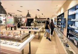  ?? Allen J. Schaben Los Angeles Times ?? PEOPLE browse cannabis items at the Artist Tree in West Hollywood. The store can’t sell food but partners with a restaurant to offer more of a lounge experience.