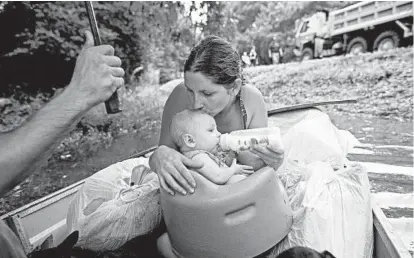  ?? MAX BECHERER/AP ?? Danielle Blount feeds her 3-month-old daughter as she waits to be rescued from floodwater­s near Walker, La., last month. A federal study found that man-made climate change doubled the chances for the type of heavy downpours that caused Louisiana ’s...