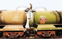  ?? — Reuters ?? A worker walks atop a tanker wagon to check the freight level at an oil terminal on the outskirts of Kolkata, India.