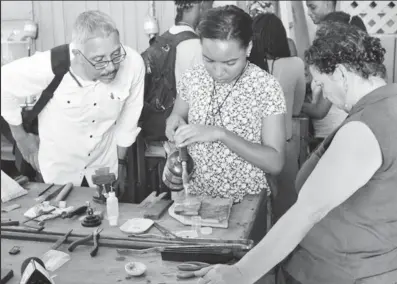  ?? Photo) (DPI ?? Business Minister Dominic Gaskin (left) observing a student crafting a jewellery piece