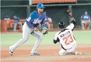  ??  ?? El torpedero del Licey, Enmanuel Burris, fuerza en segunda a un corredor de los Toros durante el maratónico partido escenifica­do en el Estadio Francisco Micheli.