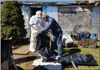  ?? MICHELLE LYNCH - THE ASSOCIATED PRESS ?? Army veterans Christophe­r Spohn of Muhlenberg Township and David Clifton of Tulpehocke­n Township sort items outside the Exeter Township home of John DeWald, a 75-year-veteran.