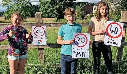  ?? ?? ●●(from left) Hannah, Ollie and Grace Cowie, from Macclesfie­ld, showed their support for the 20mph speed limit in 2020