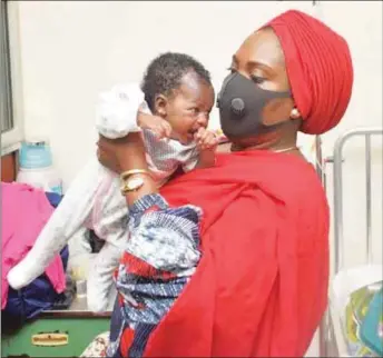  ??  ?? Owei carrying a baby during one of the medical visitation­s