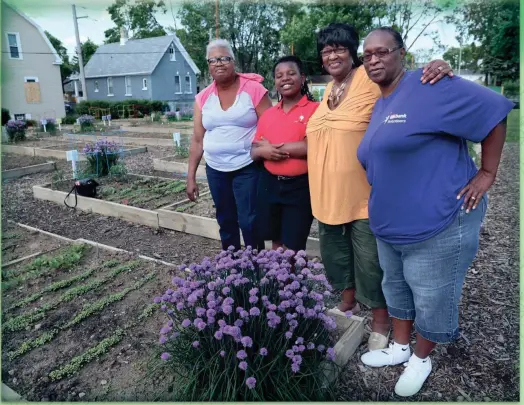  ?? MICHAEL SEARS, MILWAUKEE JOURNAL SENTINEL ?? Three generation­s at the Cherry Street Garden (from left): Linda Ginn, her granddaugh­ter Santana Webb, Rosie Woodland (Santana's other grandmothe­r) and Sandra Webb, Santana's mother.