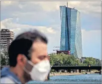  ?? [MICHAEL PROBST/ THE ASSOCIATED PRESS] ?? A man walks in front of the European Central Bank, Wednesday, in Frankfurt, Germany.