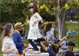  ?? KATHY WILLENS / ASSOCIATED PRESS ?? A young girl dances with her mother to the music of Alegba and Friends, a Haitian jazz and roots band performing nightly free concerts at Prospect Park’s landmark Boathouse in New York. The band’s leader, Alegba Jahyile, who is Haitian, says, “When people come here, they come to have a little good time, to have a picnic with their family, their friends, their lovers. And then the music takes them to another level.”