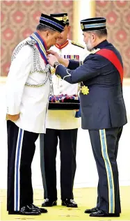  ??  ?? The Yang di-Pertuan Agong Sultan Muhammad V (right) conferring the Darjah Panglima Gagah Pasukan Polis on Bukit Aman Special Branch director Datuk Seri Mohd Mokhtar Mohd Shariff at the investitur­e ceremony held at Istana Negara. - Bernama photo