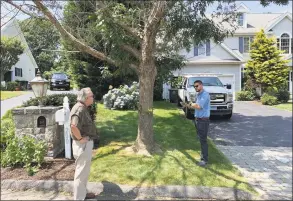  ?? / Michael P. Mayko ?? Greg Martin, Ansonia’s director of constituen­t services and Joseph Belletti, a licensed arborist and former Seymour tree warden, discuss one of the Green Ash trees ticketed for removal on Milford’s Centennial Drive. Martin and Belletti are involved in saving three large Green Ash trees in downtown Ansonia that were planned to be cut down because of Emerald Ash Borer infestatio­n.