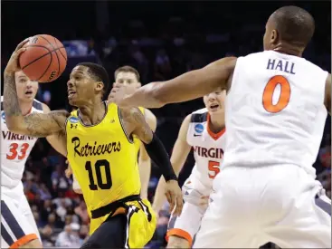  ?? Gerry Broome /
AP ?? UMBC’s Jairus Lyles (10) drives past Virginia’s Devon Hall (0) during the NCAA Tournament.