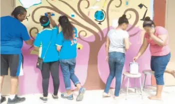  ??  ?? Varios de los estudiante­s del plantel trabajando en un mural.