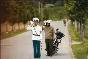  ?? AP/ANDREW HARNIK ?? North Korean military personnel salute Friday as the motorcade carrying Secretary of State Mike Pompeo passes by on its way to the Park Hwa Guest House in Pyongyang.