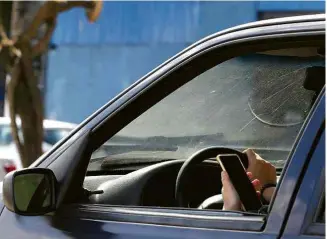  ?? Rivaldo Gomes/Folhapress ?? Motorista tira mão do volante para segurar o celular em São Paulo