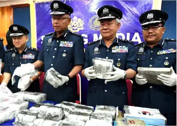  ?? — Bernama photo ?? Zulkifli (second left) with Hamza (second right) and other Customs officers showing the seized drugs.