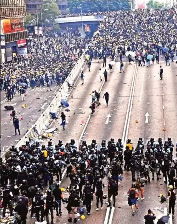  ?? ANTHONY WALLACE/AFP ?? Protesters face off with police after authoritie­s fired tear gas during a rally against a controvers­ial extraditio­n law proposal outside the government headquarte­rs in Hong Kong on Wednesday.
