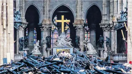  ?? PHOTO: REUTERS ?? Charred remains . . . Debris is strewn over the floor of NotreDame de Paris yesterday in the aftermath of Tuesday’s fire that devastated the cathedral.