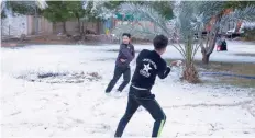  ?? — AFP ?? Iraqi boys play with snow in Karbala.