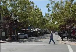  ?? ALAN DEP — MARIN INDEPENDEN­T JOURNAL ?? A pedestrian crosses Grant Avenue on Wednesday in the Old Town section of Novato. City officials and business leaders say closing the street to vehicles on weekends had a mixed effect on commerce.