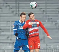  ?? FOTO: ULI DECK/DPA ?? Die Torschütze­n beim Unentschie­den: Der Karlsruher Robin Bormuth (links) und der Heidenheim­er Christian Kühlwetter kämpfen um den Ball.