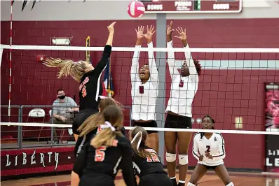  ?? Staff photo by Kelsi Brinkmeyer ?? ■ Liberty-Eylau players Ja'Niya Sanders and Myah Hurd block the ball from going over the net at their game against Gilmer on Tuesday at Rader Dome.