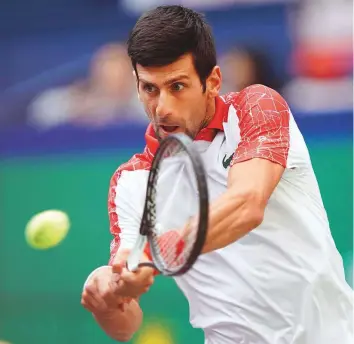  ?? AFP ?? Novak Djokovic powers a backhand against Marco Cecchinato in the third round of the Shanghai Masters yesterday. The Serb won 6-4, 6-0.