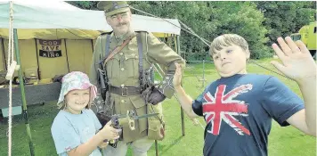  ??  ?? Rob Thrush of the 10th Battalion Essex Regiment watches as Maisie Jenssen makes Theo Davis put ‘em up!