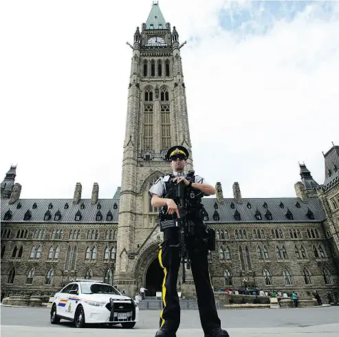  ?? SEAN KILPATRICK / THE CANADIAN PRESS ?? An RCMP officer stands watch on Parliament Hill in Ottawa on Monday, where a DND official says a “potential threat was identified and neutralize­d” around 10:15 a.m. during the Changing of the Guard Parade.