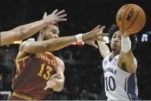  ?? AP photo ?? Iowa State’s Jaren Holmes passes under pressure from Kansas’ Jalen Wilson during the Jayhawks’ 71-58 win over the Cyclones in a Big 12 tournament semifinal Friday.