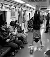  ?? DAI BING / FOR CHINA DAILY ?? Gymnast Zhang Shangwu performs in a subway car.